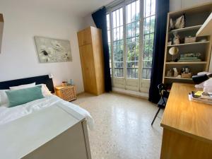 a bedroom with a bed and a desk and a window at Barcelona Housing Student in Barcelona