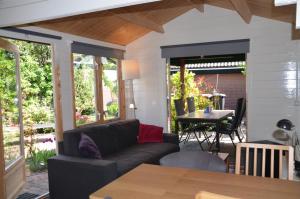a living room with a couch and a table at Chalet t Kla-viertje in Klarenbeek