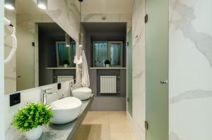 un baño con dos lavabos y dos espejos en Underground Hostel, en Kiev 30 fotos más