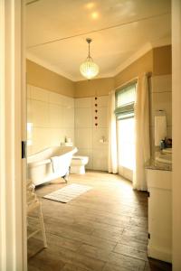La salle de bains est pourvue d'une baignoire, de toilettes et d'un lavabo. dans l'établissement The Lighthouse Guesthouse, à Colesberg