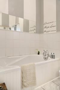 La salle de bains blanche est pourvue d'une baignoire et d'un miroir. dans l'établissement The Lighthouse Guesthouse, à Colesberg