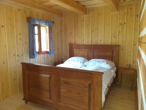 a bedroom with a wooden bed in a cabin at Roubenka Telecí in Telecí