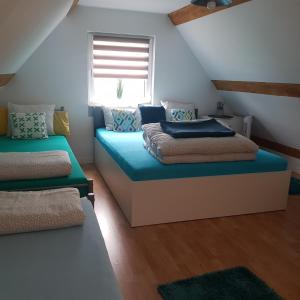 a attic bedroom with two beds and a window at Domek Adam - Kozy in Kościerzyna