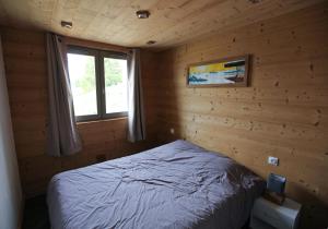 フォン・ロムーにある11 rue des Irisの木造キャビン内のベッド1台が備わるベッドルーム1室を利用します。
