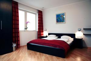 una camera con un letto con una coperta rossa di La Scala Apartments a Vienna