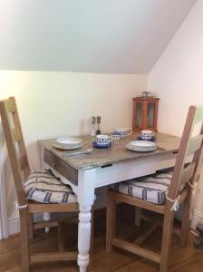 Melbury في Rudgwick: طاولة خشبية عليها كرسيين وطاولة عليها لوحات