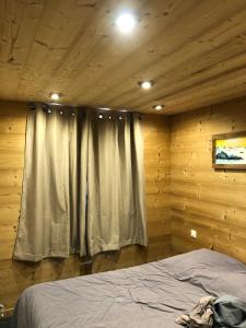 フォン・ロムーにある11 rue des Irisの木製の部屋にベッド1台が備わるベッドルーム1室があります。