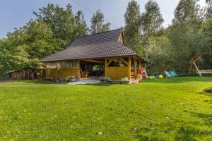 a log cabin in a yard with a grass field at Wiśniowy Gaj in Ujanowice