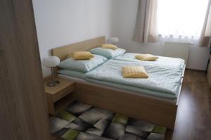 a bedroom with a bed with blue sheets and yellow pillows at Apartmány IVKA a MAŤKO DONOVALY 198 in Donovaly