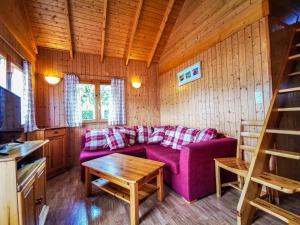 ein Wohnzimmer mit einem lila Sofa und einem Tisch in der Unterkunft PRL Le Védrignans - PRL El Pastural in Saillagouse