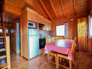 uma cozinha com uma mesa e um frigorífico azul em PRL Le Védrignans - PRL El Pastural em Saillagouse