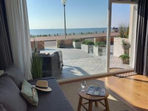 a living room with a couch and a view of the beach at Benny's Beach House 2 in Zandvoort