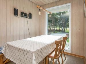 a table in a room with a table and two chairs at 6 person holiday home in R m in Bolilmark