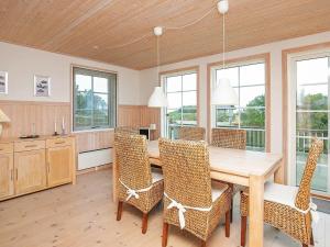 a dining room with a wooden table and chairs at 6 person holiday home in L s in Læsø