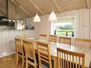 a dining room with a large wooden table and chairs at Holiday home Væggerløse XVI in Marielyst