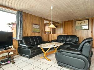 Lakolkにある6 person holiday home in R mのリビングルーム(黒い革張りの椅子、テーブル付)