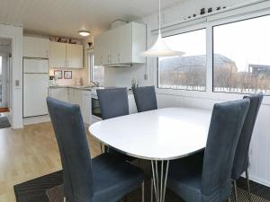 蘇納維的住宿－4 person holiday home in Ringk bing，厨房以及带白色桌椅的用餐室。
