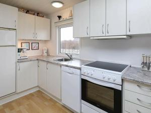 蘇納維的住宿－4 person holiday home in Ringk bing，厨房配有白色橱柜、水槽和炉灶。