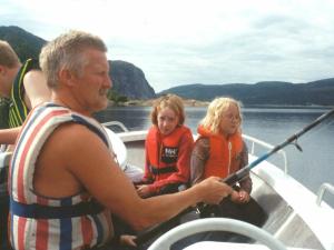 Årfor的住宿－7 person holiday home in Foldereid，水中船上的一个男人和两个孩子