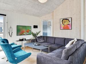 a living room with a gray couch and two blue chairs at Holiday home Grenaa XI in Grenå