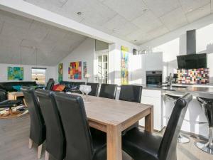a kitchen and dining room with a wooden table and chairs at 8 person holiday home in Ringkøbing in Ringkøbing