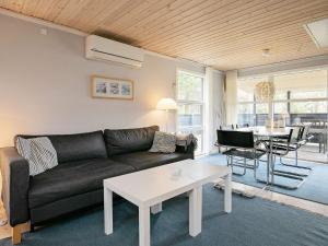 a living room with a couch and a table at Three-Bedroom Holiday home in Væggerløse 6 in Bøtø By