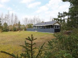 a small house in a field with a yard at Three-Bedroom Holiday home in Væggerløse 6 in Bøtø By