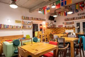 a restaurant with wooden tables and chairs and bookshelves at Trafo Base Camp in Kroczyce