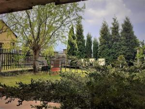 een tuin met banken, een boom en een hek bij APARTAMENT POD DZIEWIĄTKĄ in Sandomierz