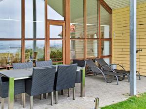 a group of chairs and tables on a patio at 6 person holiday home in Egernsund in Egernsund