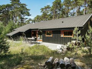 a black house with a picnic table in front of it at 8 person holiday home in Nex in Spidsegård