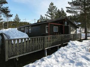 a small cabin with a wooden deck in the snow at 8 person holiday home in SERAL in Hamkoll