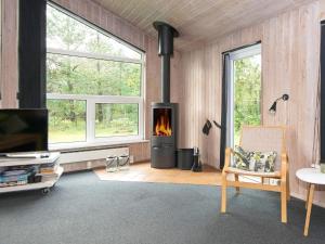 sala de estar con chimenea y silla en 12 person holiday home in Bl vand, en Ho