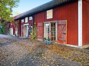 une grange rouge avec une allée devant elle dans l'établissement Holiday home ÖDESHÖG, à Ödeshög