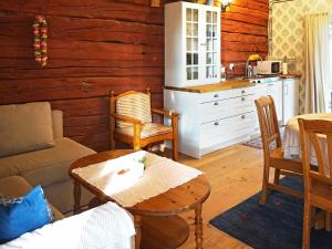 a living room with a table and a kitchen at Holiday home ÖDESHÖG in Ödeshög
