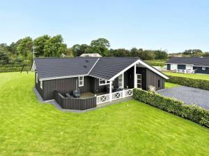 uma pequena casa com um grande quintal em frente em Holiday home Hadsund XLIX em Sønder Hurup