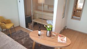 a living room with a table with a bottle and glasses at Landhotel Hermannshöhe in Legden
