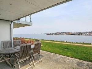 スタイにある5 person holiday home in Stegeの水辺の景色を望むパティオ(テーブル、椅子付)