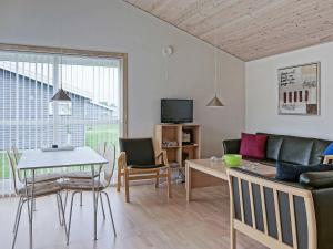 ein Wohnzimmer mit einem Sofa und einem Tisch in der Unterkunft 4 person holiday home in Gudhjem in Gudhjem