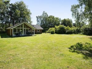 a small house in a field with a grass yard at Three-Bedroom Holiday home in Højby 1 in Højby
