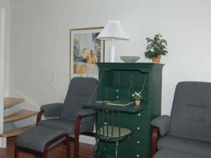 ブラーバンドにある6 person holiday home in Bl vandの椅子、緑のキャビネット、テーブルが備わる客室です。