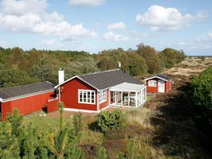 een rood huis in het midden van een veld bij 6 person holiday home in lb k in Ålbæk