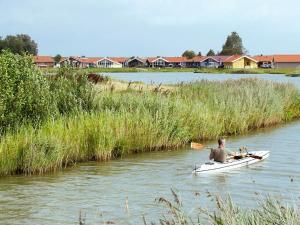 a man is in a boat on a river at 6 person holiday home in Otterndorf in Otterndorf