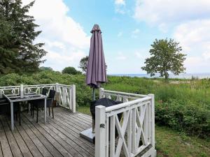 een houten terras met een parasol en een tafel bij 4 person holiday home in Oure in Oure