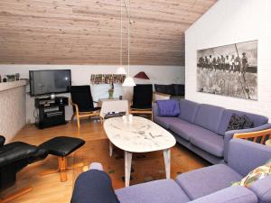 sala de estar con sofá púrpura y mesa en Three-Bedroom Holiday home in Thisted 4, en Nørre Vorupør
