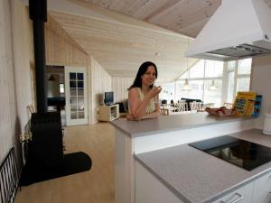 a woman standing behind a counter in a kitchen at 10 person holiday home in R dby in Kramnitse