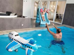 un hombre y un niño jugando en una piscina en 14 person holiday home in Sydals en Høruphav