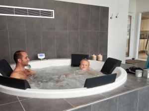 un hombre y un niño sentados en una bañera en 14 person holiday home in Sydals en Høruphav