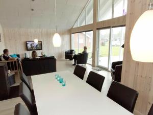 uma sala de reuniões com uma mesa branca e cadeiras em 14 person holiday home in Sydals em Høruphav