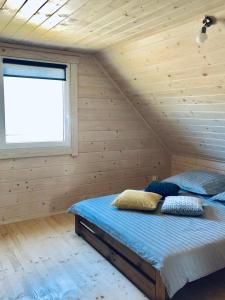 a bedroom with a bed in a wooden room at Merinn in Rogowo